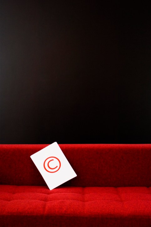 Copyright icon sitting on a red couch