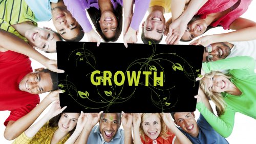 Group of People all Holding Sign Saying Growth